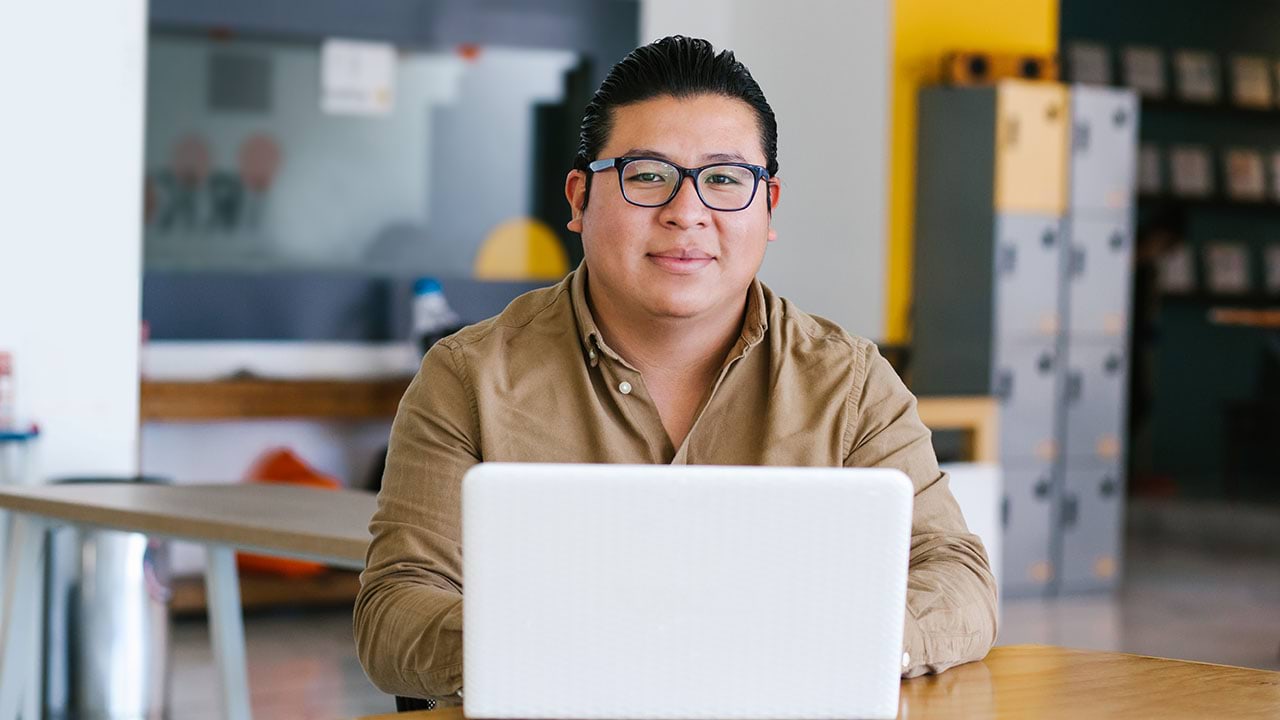 Person using a computer, looking at the camera