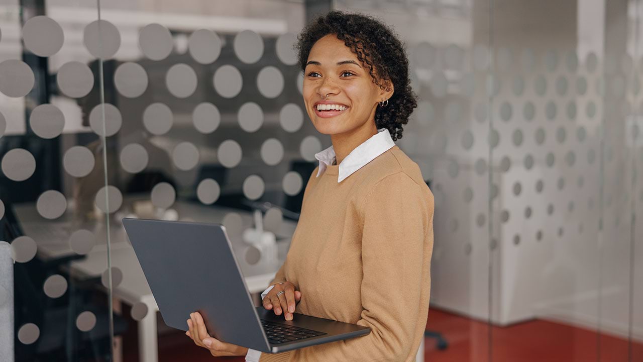 Person holding laptop in an office setting