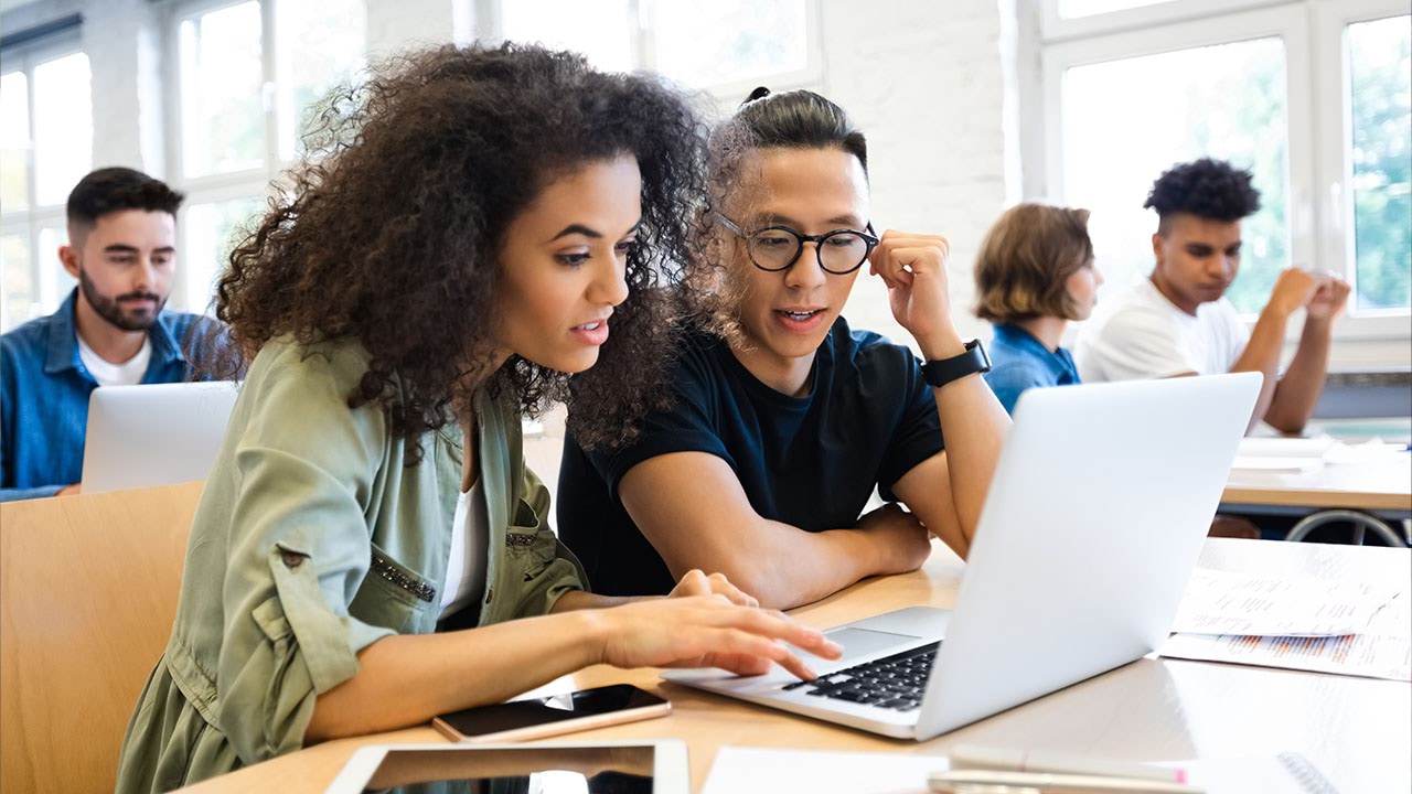 Two people looking into laptop together