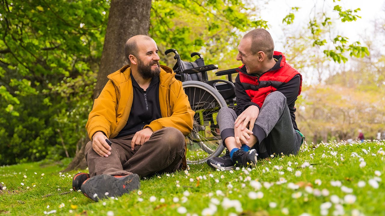 Disability support worker with client in park