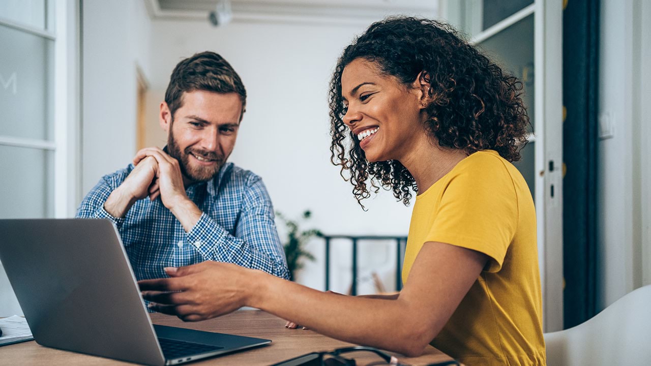 Two people working together on a laptop