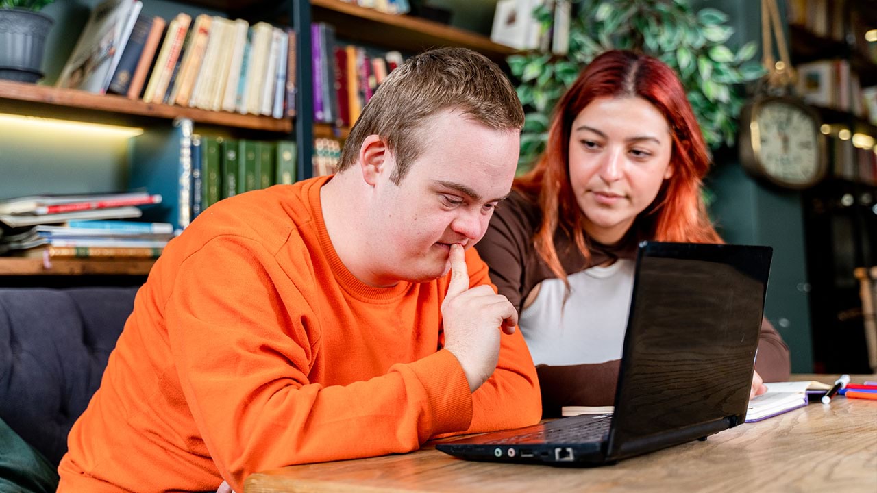 Two people looking into laptop together