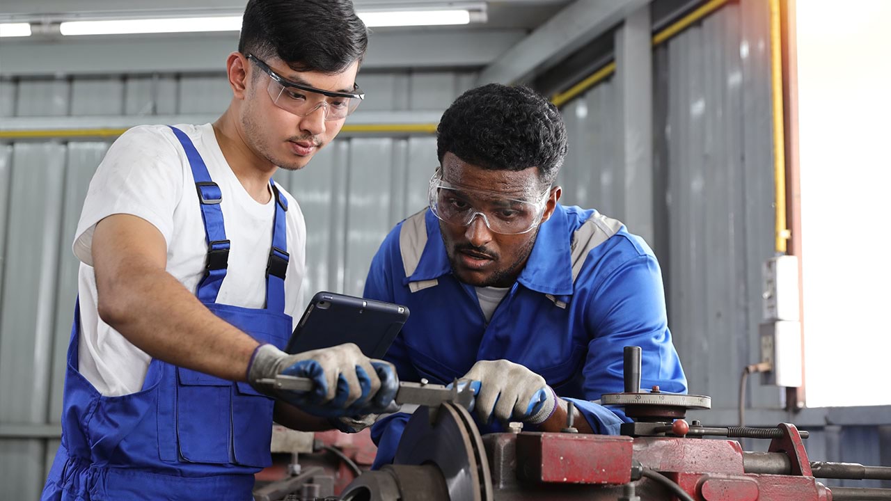 Two people in metal workshop