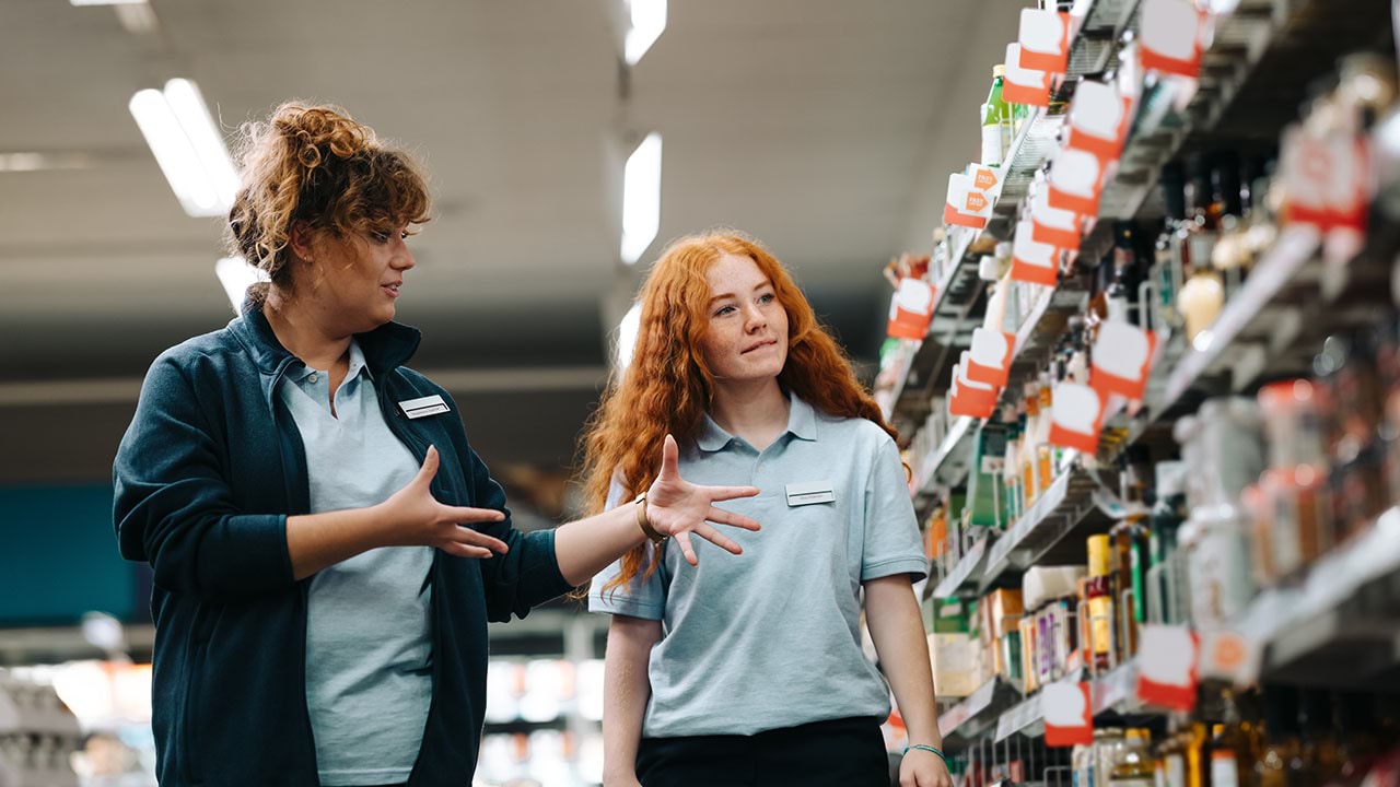 Two workers in supermarket setting