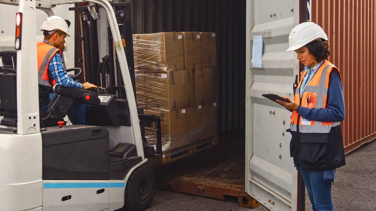 Team using forklift to place boxes into shipping container