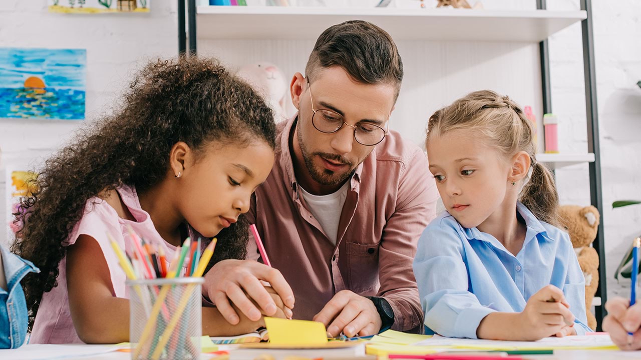 Adult with two children working on drawing skills