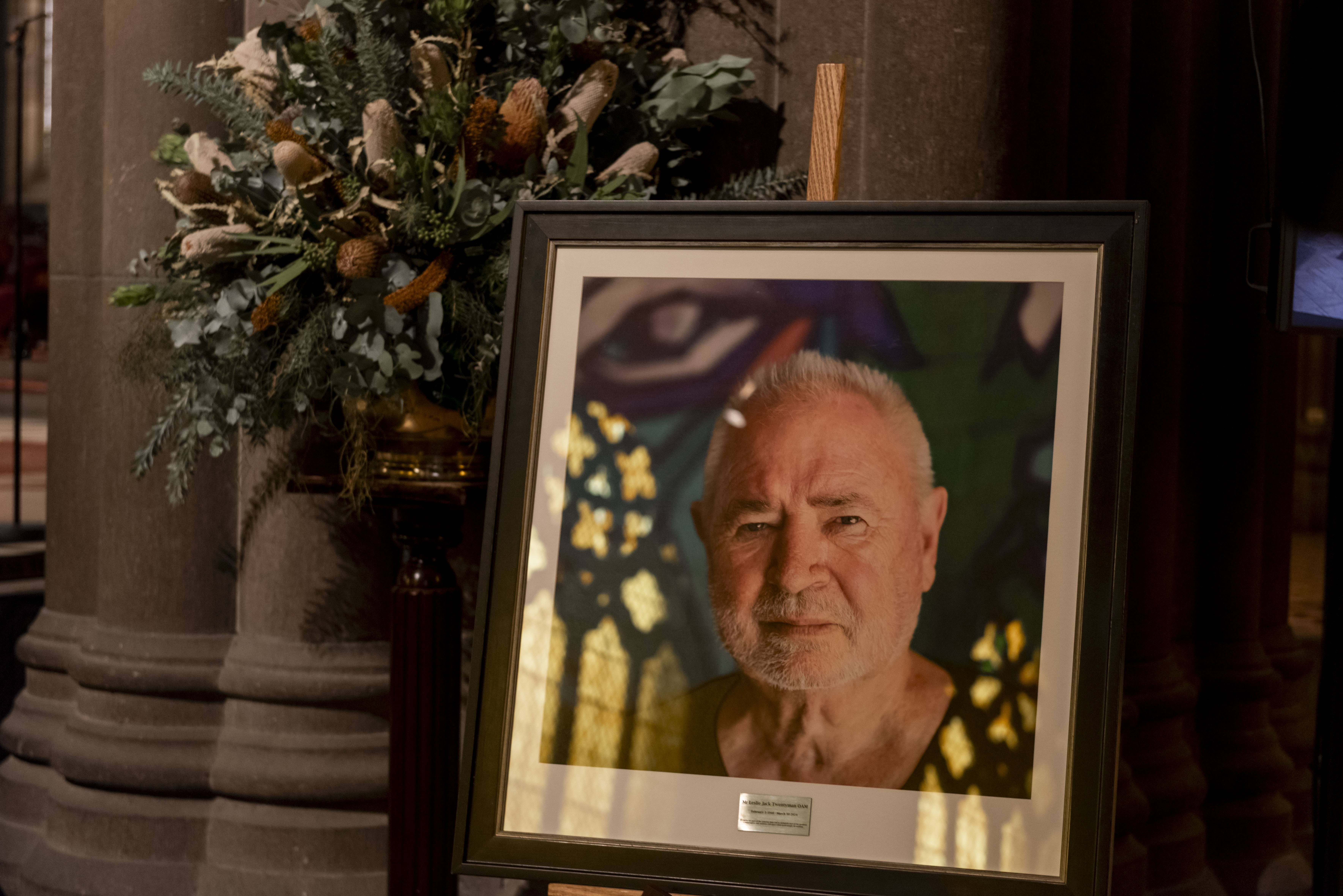 Framed photo of Leslie Twentyman OAM with a bunch of flowers positioned behind.  