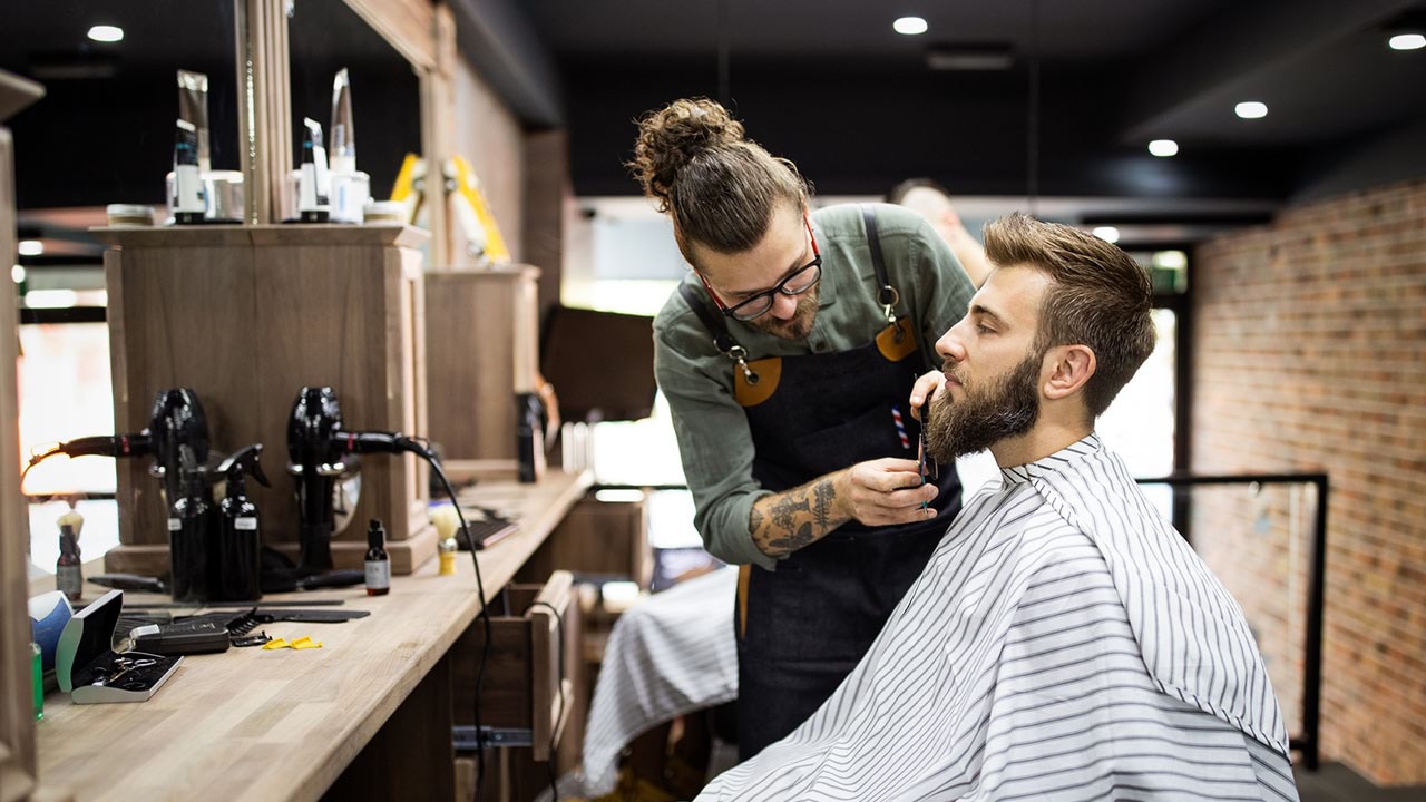 Barer giving a beard trim to client