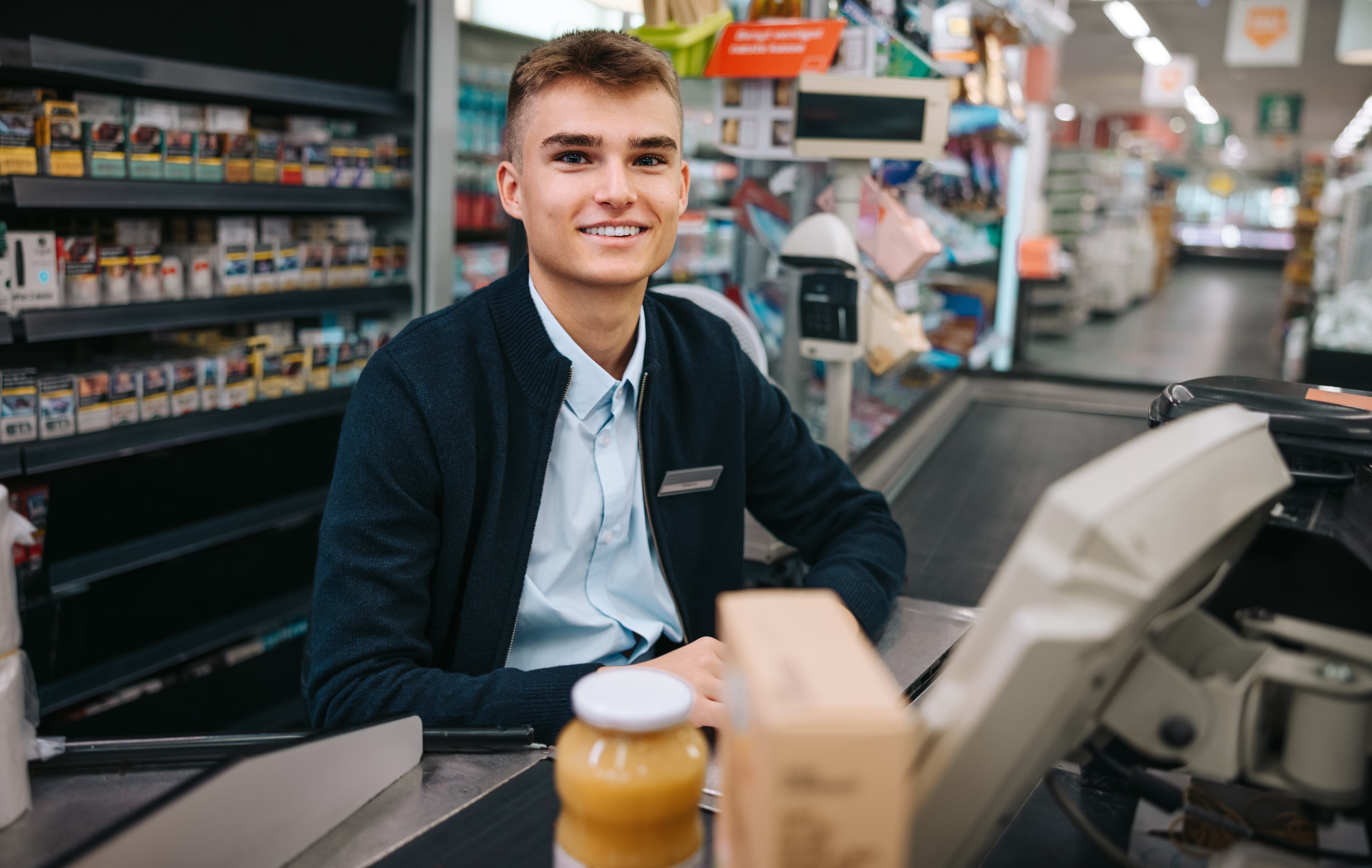 teenager working at cash register 