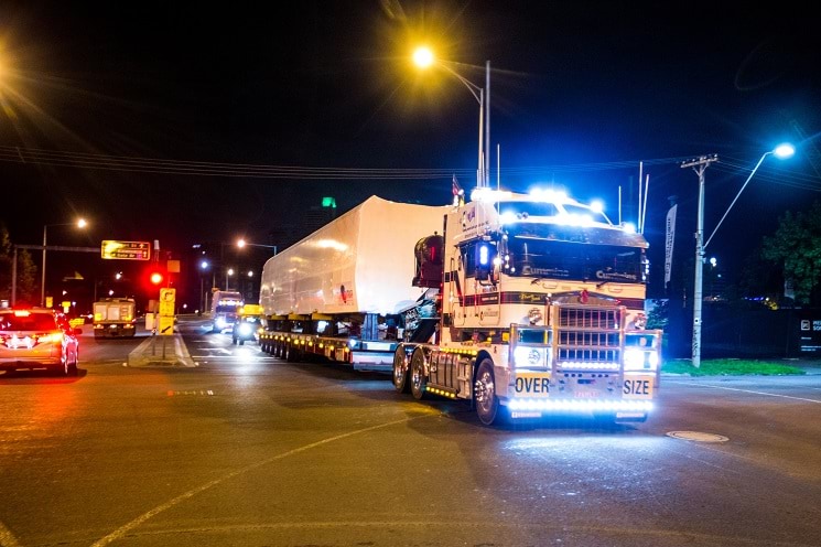 Truck at night towing a large structural component