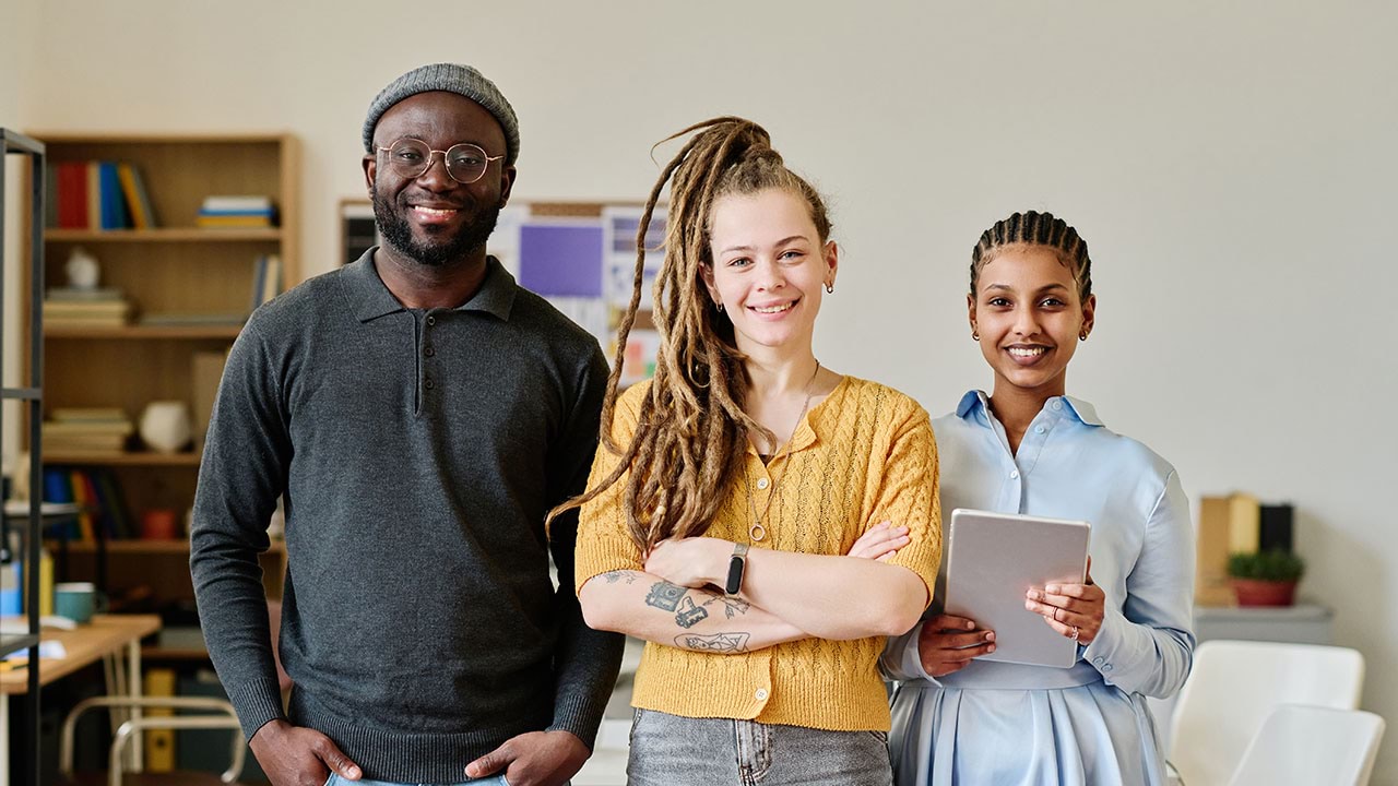 Three people looking into the camera in an adult learning environment