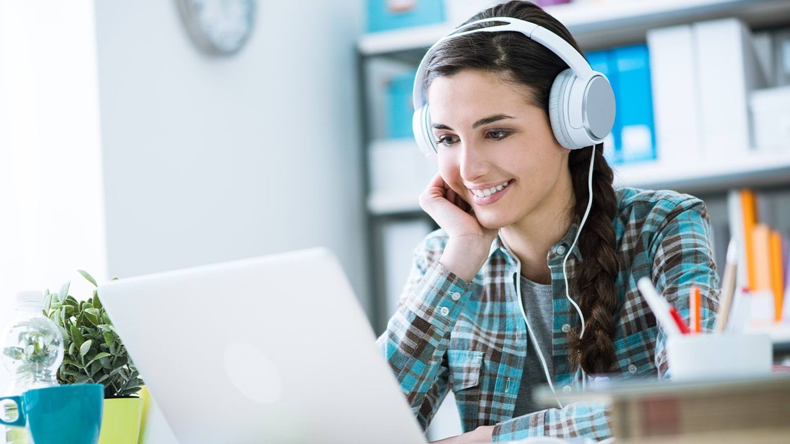 Learn about training course and qualification levels Student wear headphones using a laptop