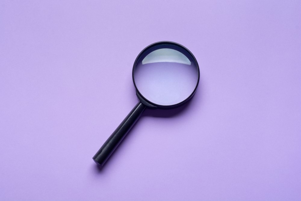 Magnifying glass on purple background