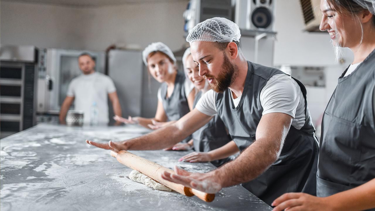 Baker teaching students learning how to bake