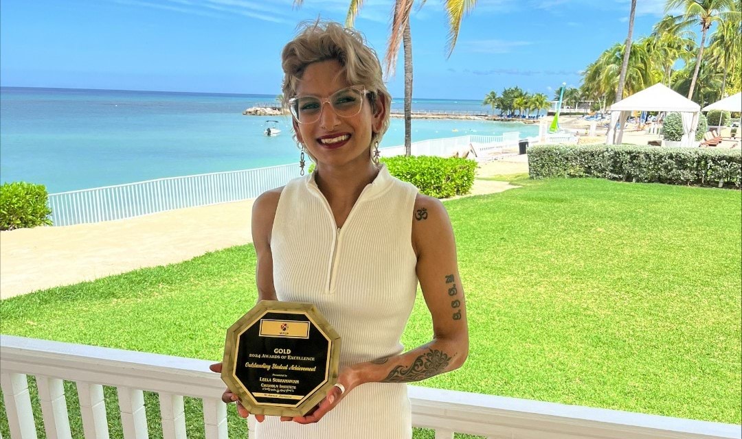 Person standing near a beach holding a trophy