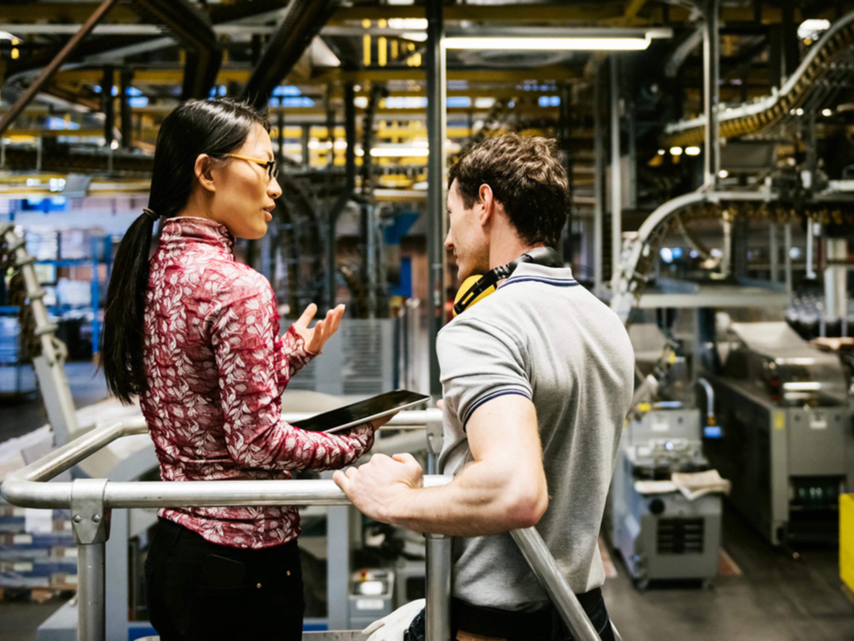 Mechanic And Female Engineer Talking in Factory