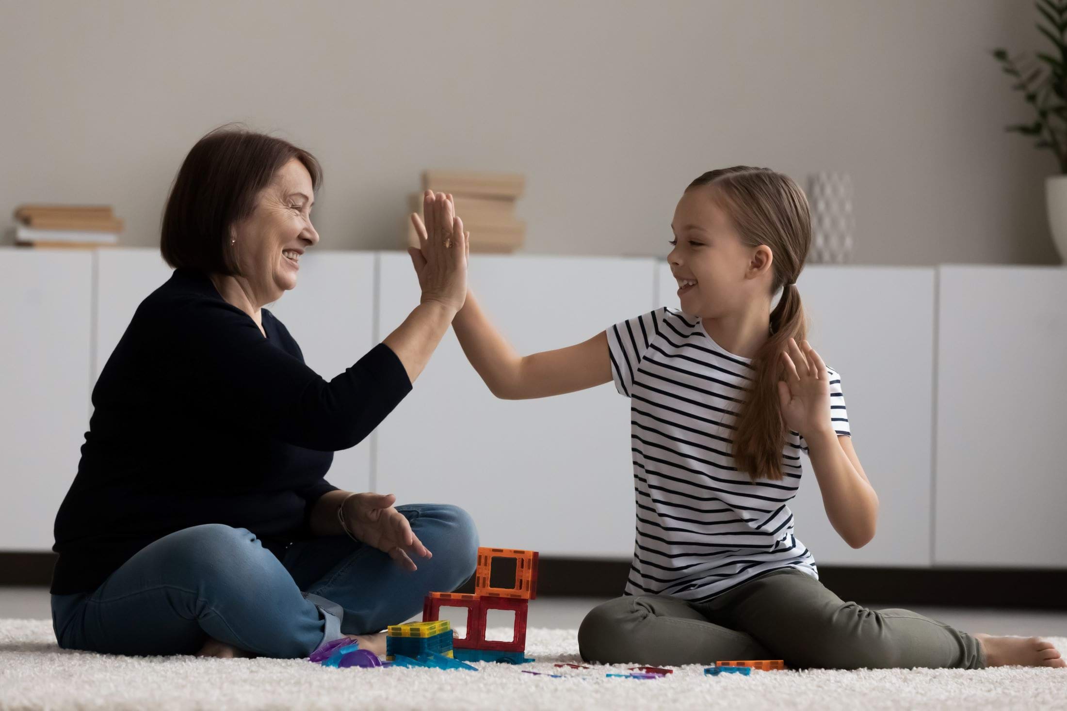 Foster carer giving a young girl in her care a high five