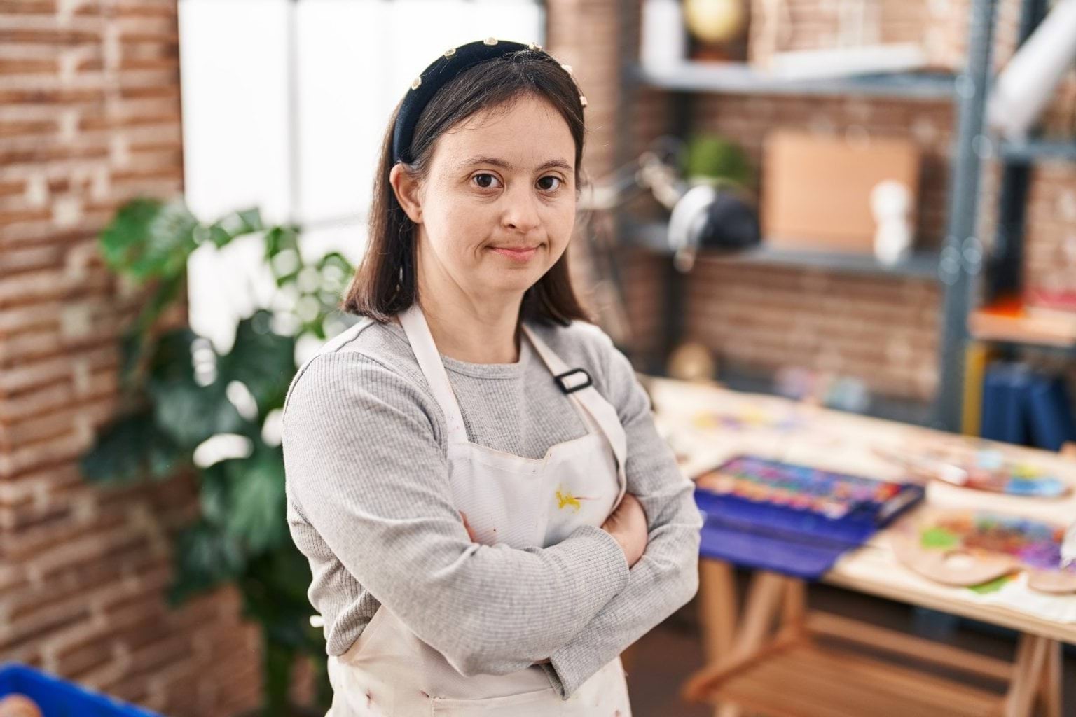 Painter with a disability standing with her arms crossed