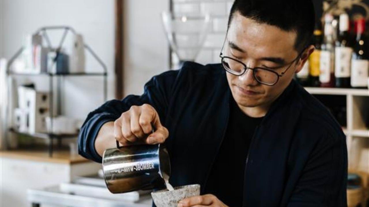 Barista pouring coffee in a cafe