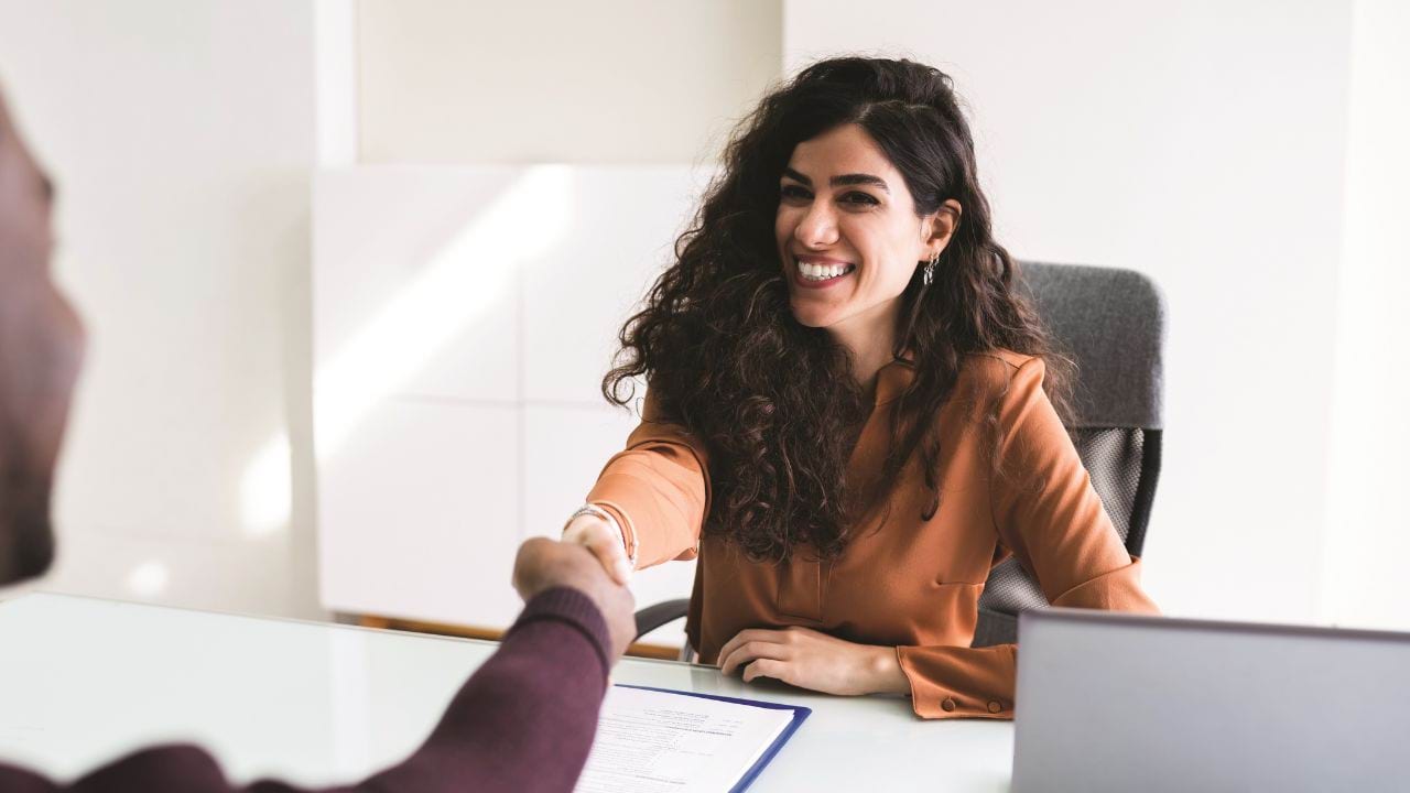 Two people shaking hands in a meeting room