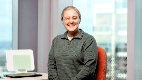 A woman sitting at a desk with her hands in her lap