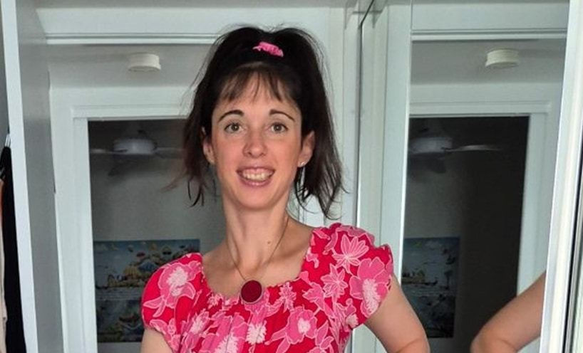 Woman in a red and pink dress standing in front a white background