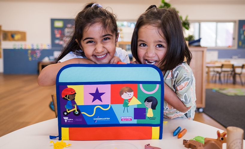 Two children holding a kinder kit.