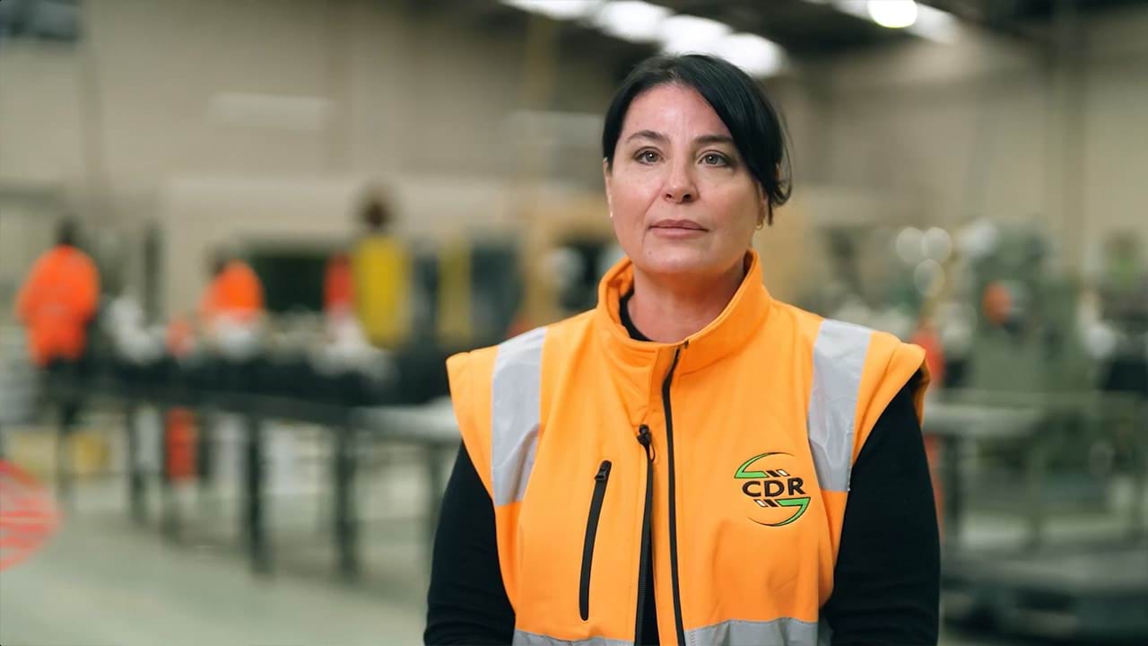 Employer Satisfaction Survey participant Cathy wearing a hi-vis vest in an industrial setting