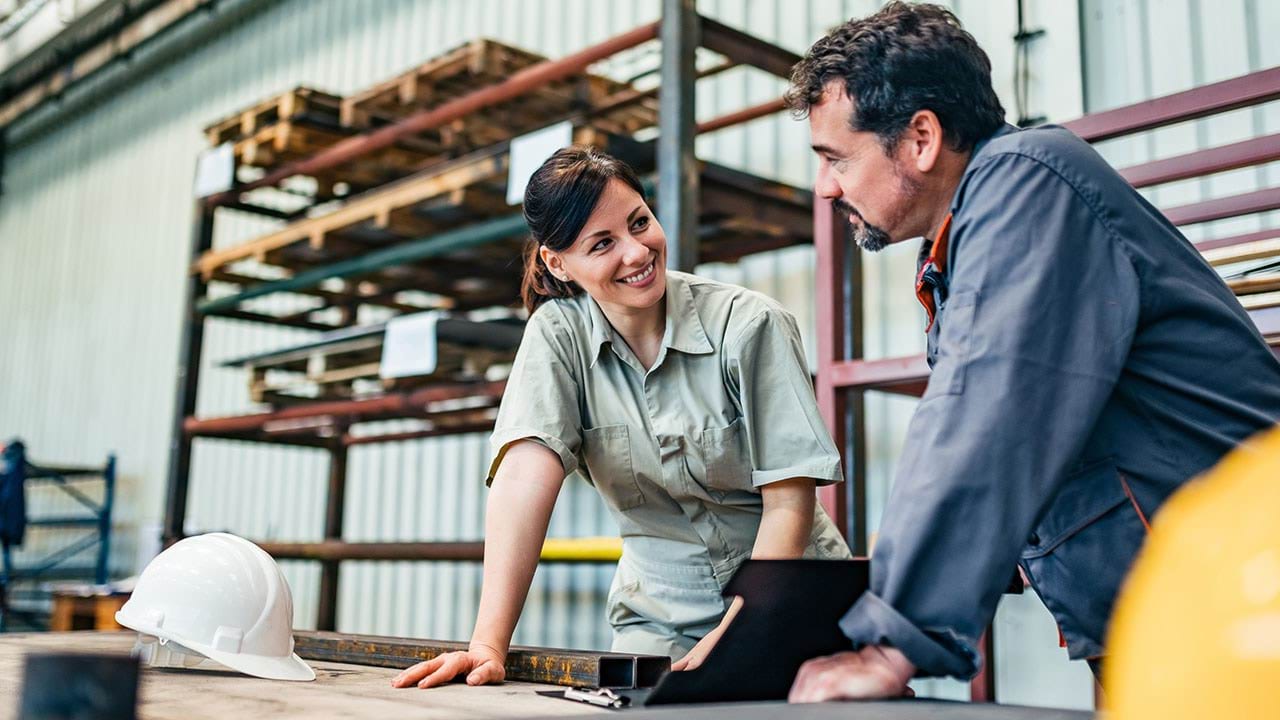 Two people working in a timber warehouse