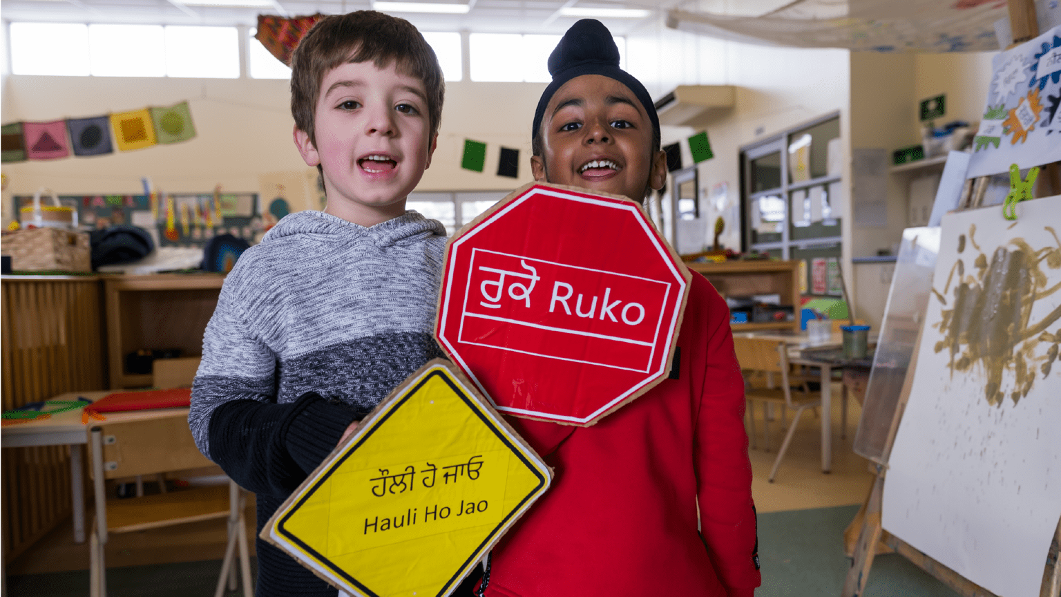 Children hold road signs in their languages
