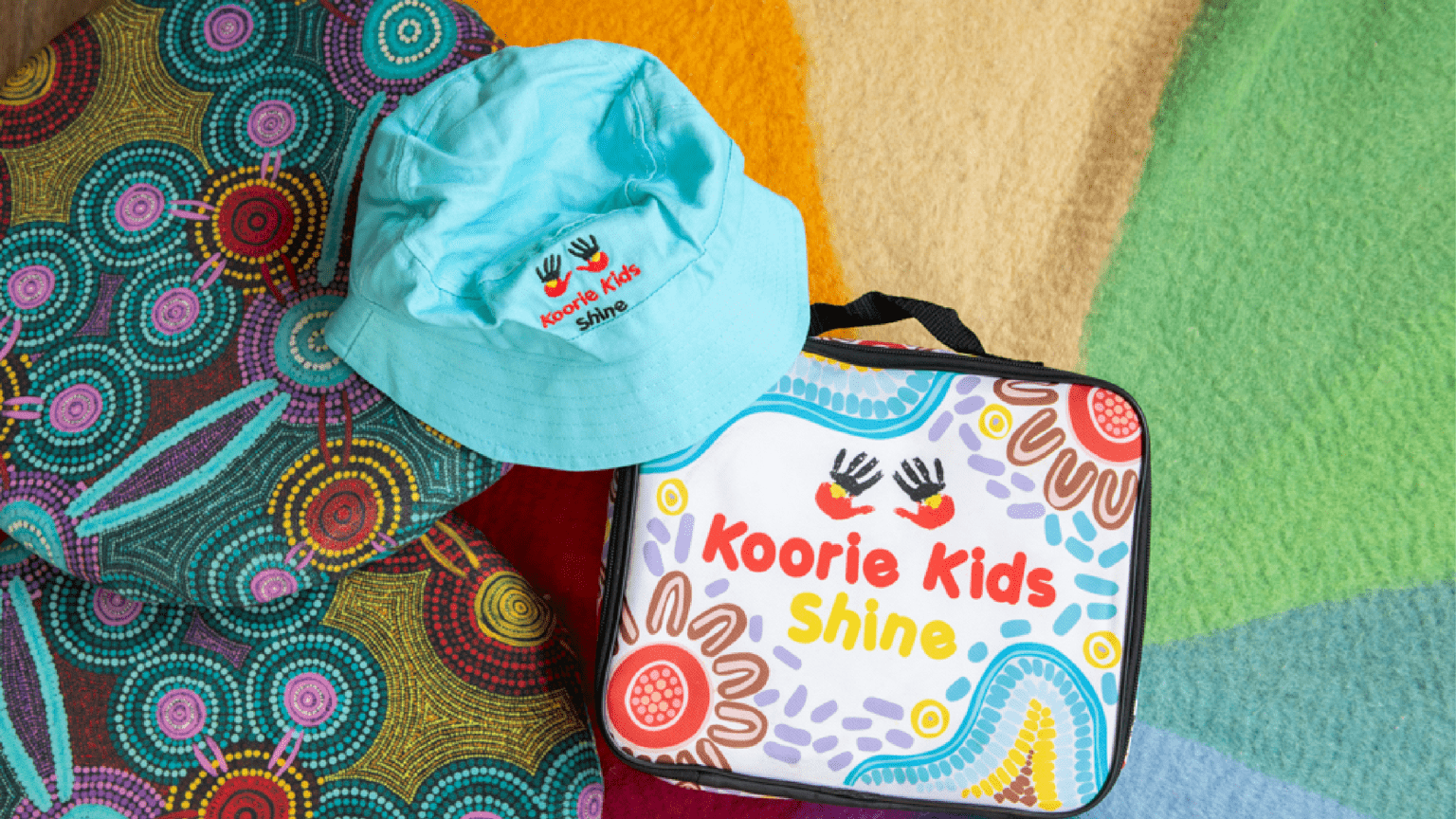 A hat and a lunch bag with Koorie Kids Shine motives on it