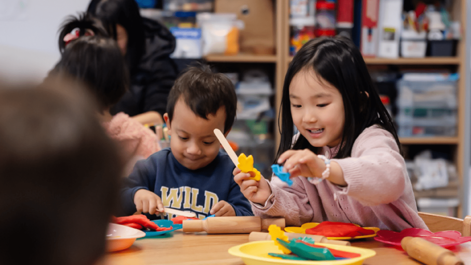 Two kids are playing on a table