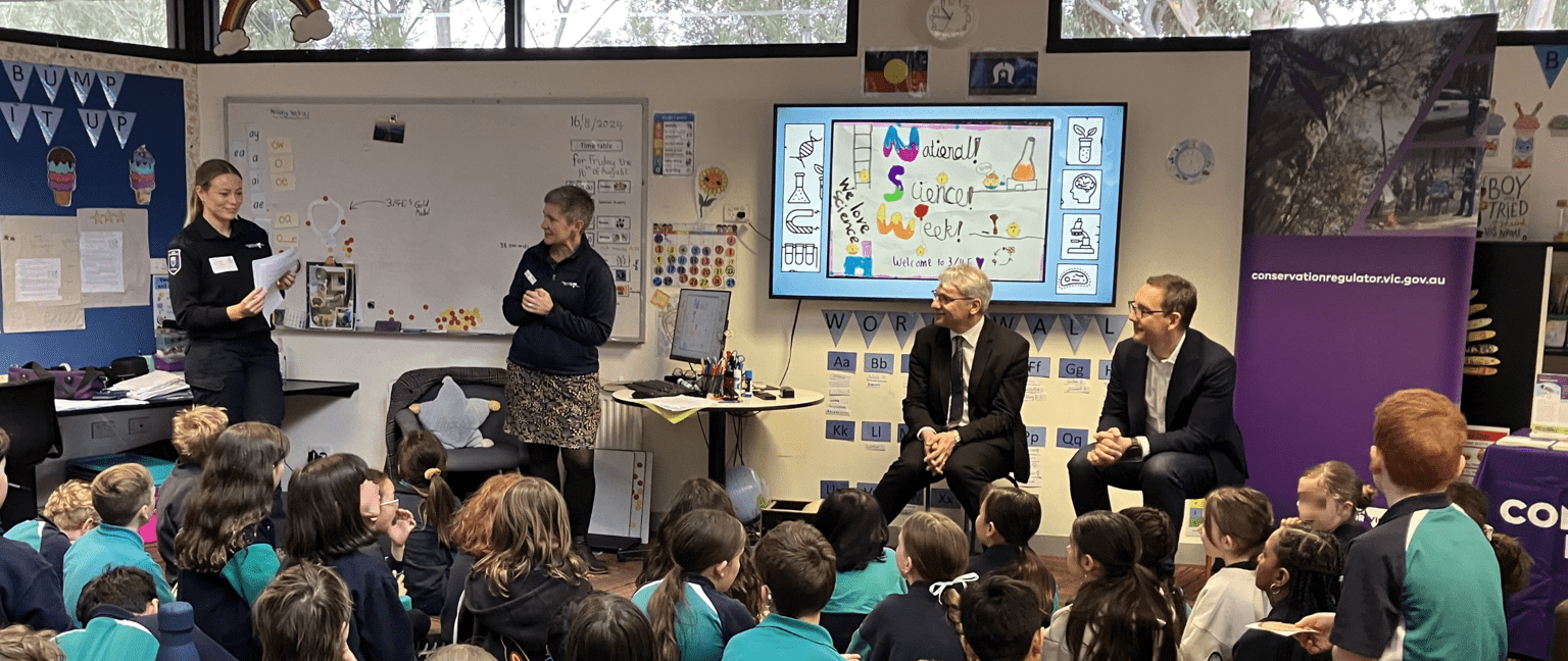 A classroom of students listen to a Forest and Wildlife officer speak