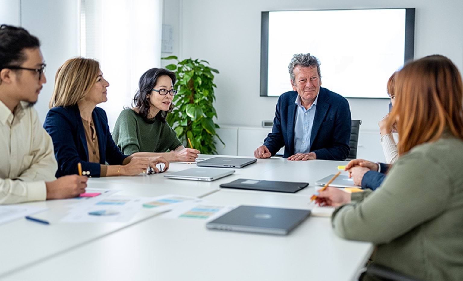 A group of people sitting around a board table