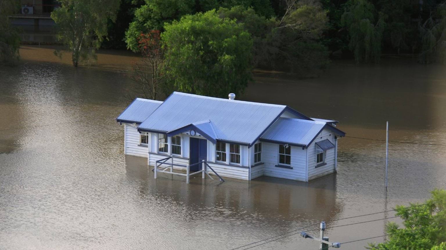 A flooded house surrounded by water A flooded house surrounded by water