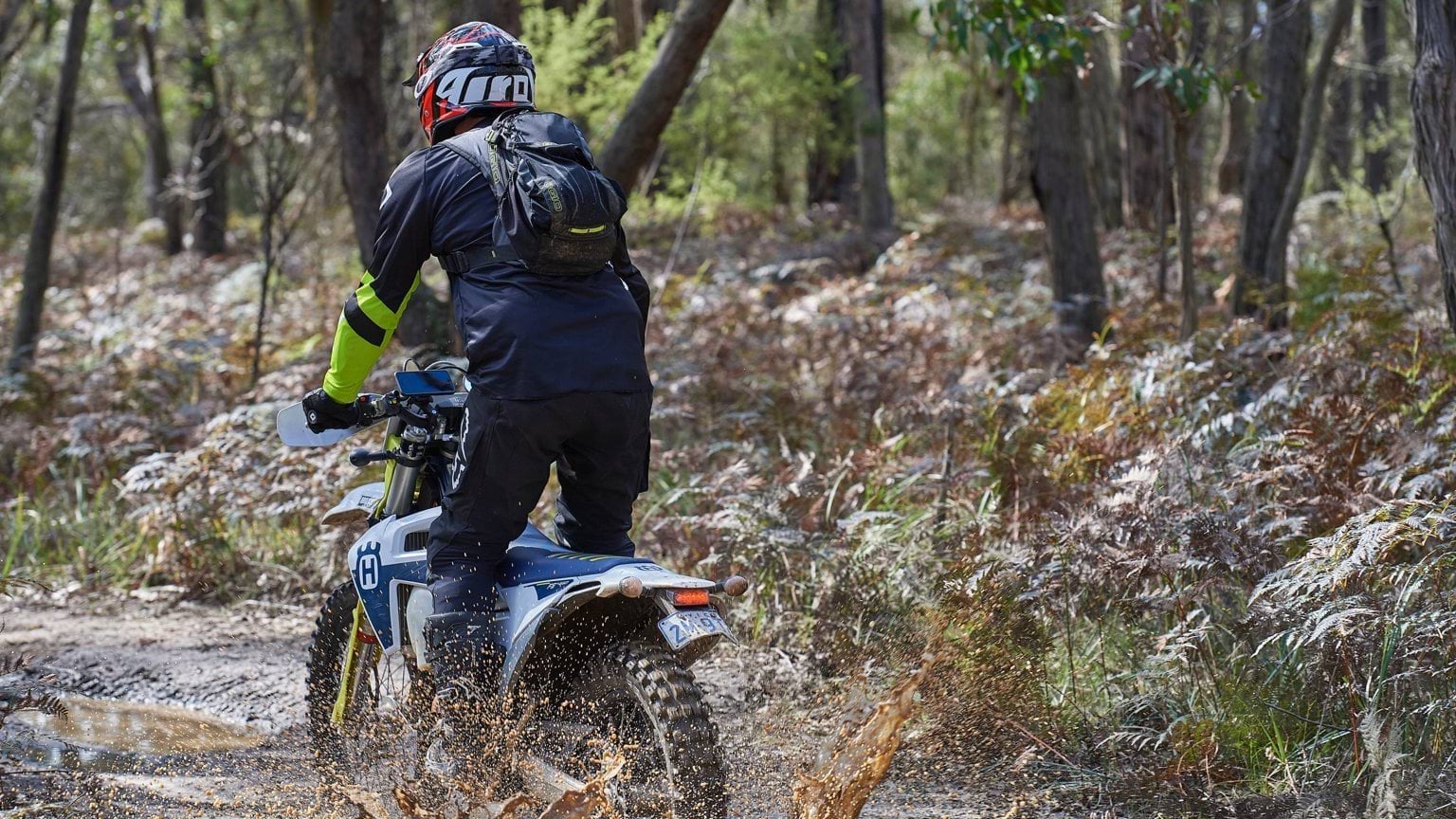 Riding a trailbike on a muddy road within a Victorian Forest.