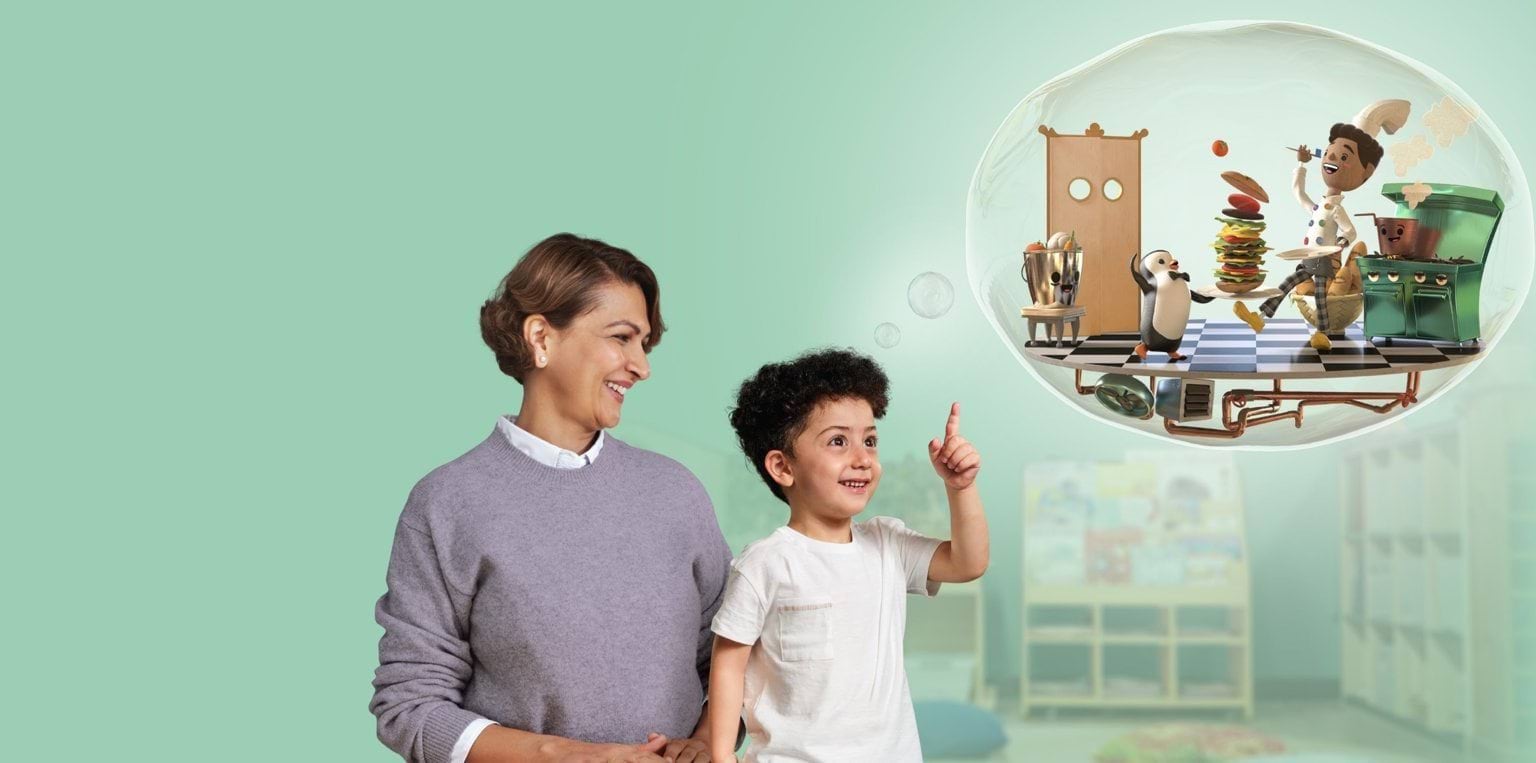 A smiling woman and a young child stand together in front of a playground. The child points excitedly to a thought bubble above them, showing a playful cartoon scene of a chef and penguin in a kitchen, joyfully preparing a towering burger. The background is a soft mint green.