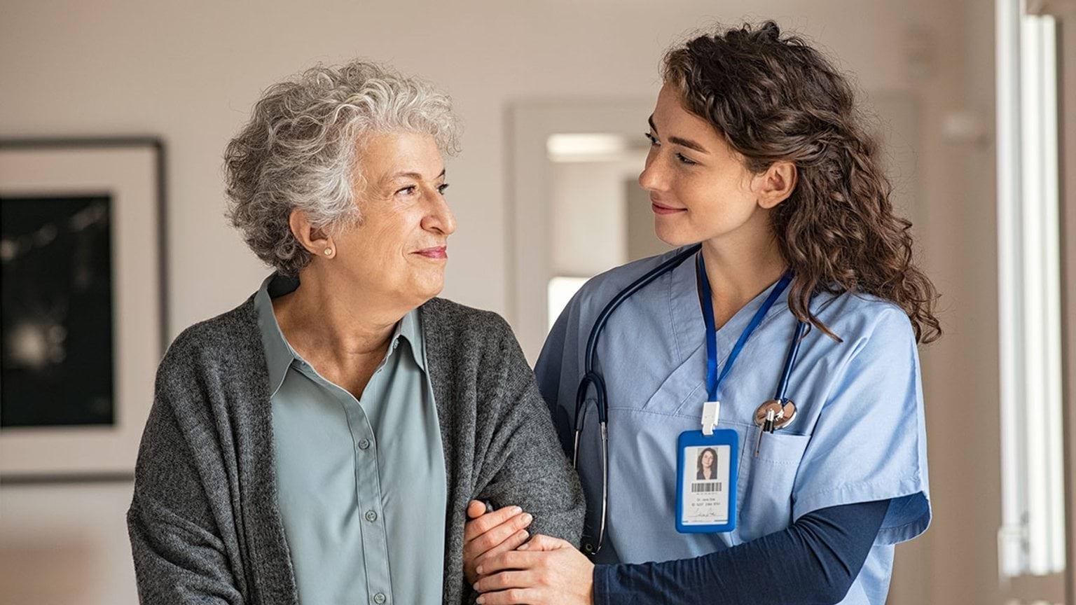 Aged carer standing with elderly person