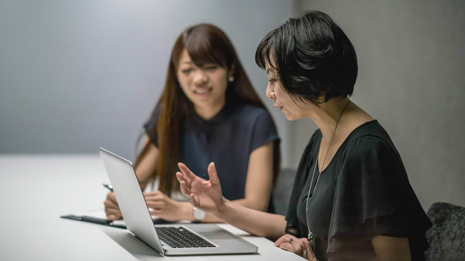 Two people working on laptop