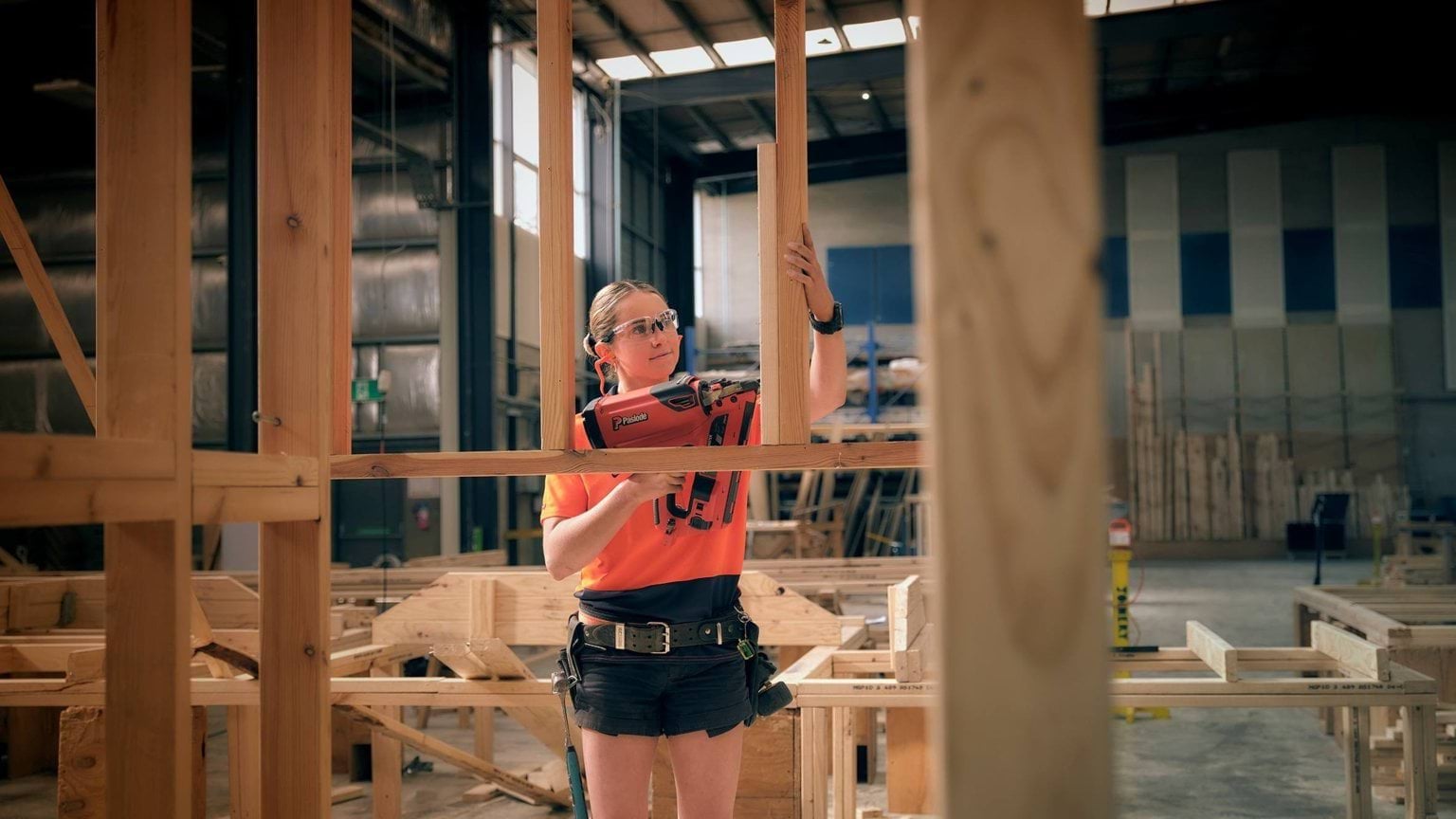 Clea using cordless nailer to create a construction frame
