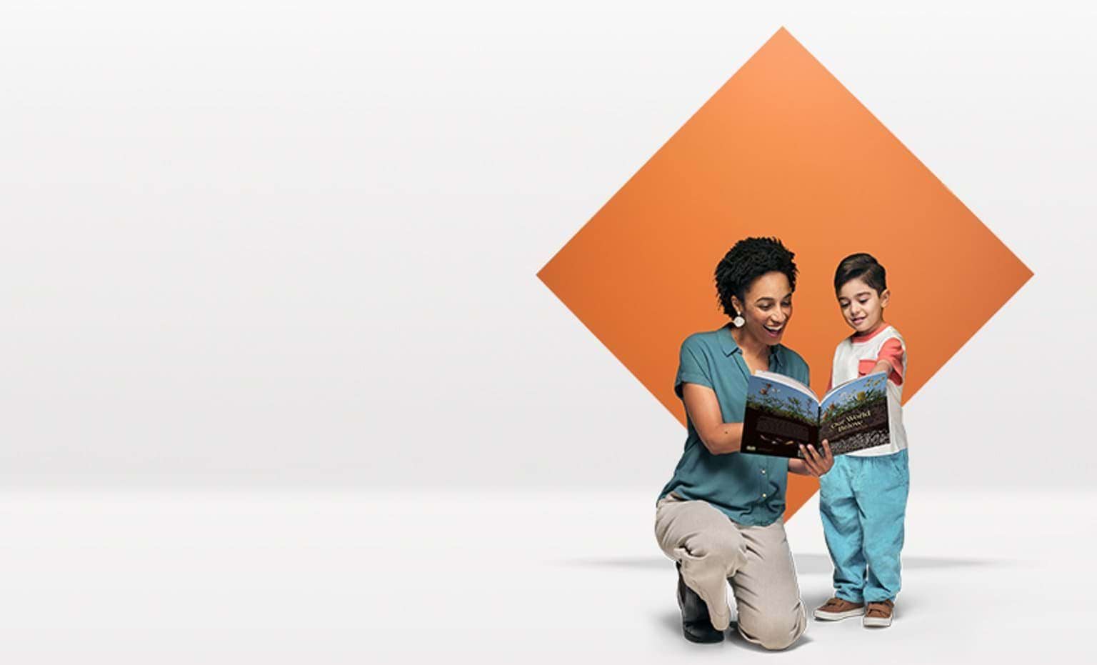 An early childhood teacher reads with a young boy in front of a orange diamond floating in a white space.