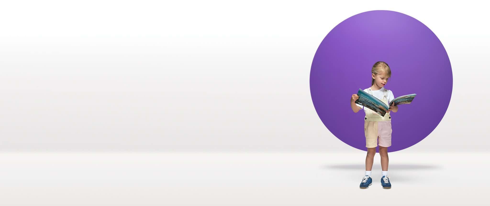 A child reads a picture book in front of a purple circle floating in a white space.