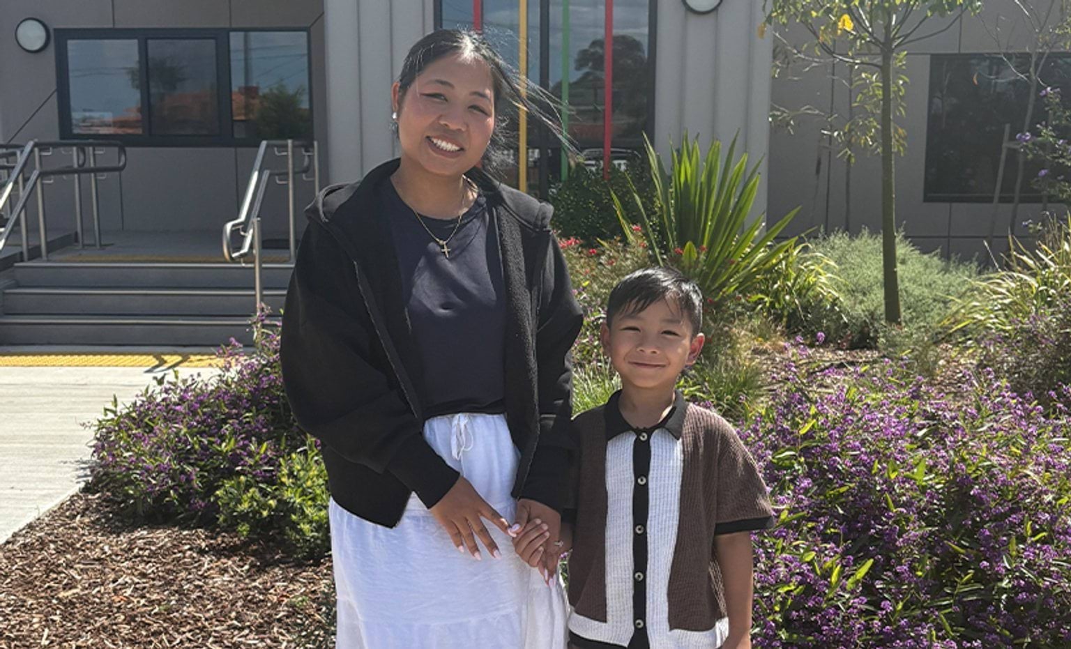 A child standing beside an adult, smiling