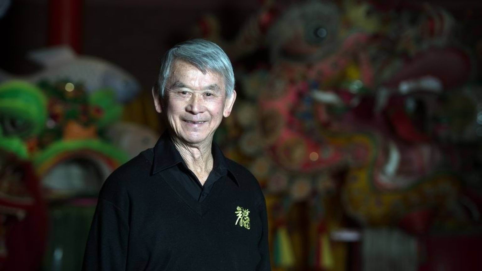 A portrait of Russell Jack AM smiling while standing in front of an imperial dragon