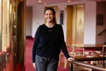 Emma standing and smiling in a foyer