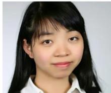 Lady with long black hair smiling in front of camera